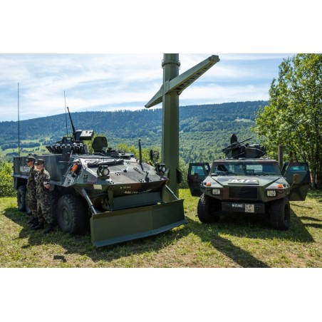 Membres de la police militaire aux côtés d’un char de grenadiers à roues Piranha et d’un véhicule d’exploration Eagle